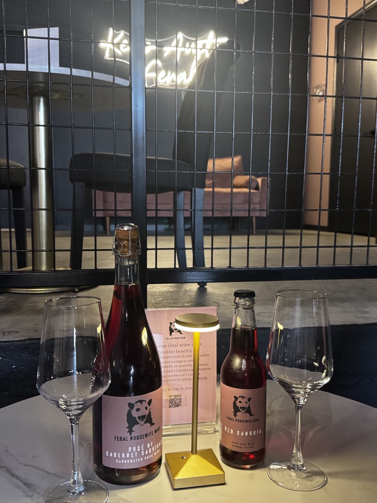 Feral Housewife rosé and red sangria bottles set for a tasting in the tasting room